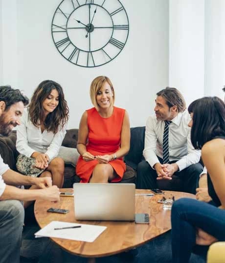 Team meeting around a laptop in a lounge area